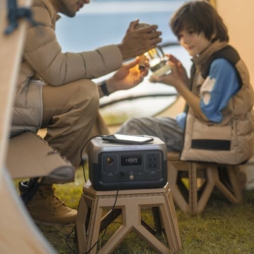 Two people in a tent using a portable power station.